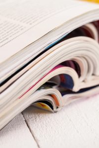 Pile of colorful magazines on a white table